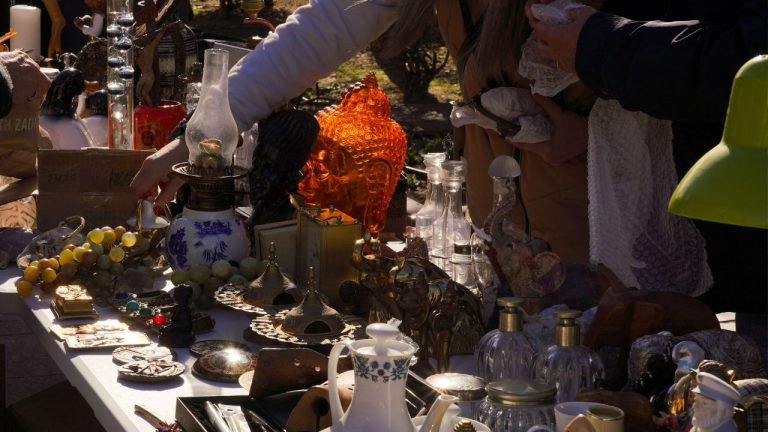 Mesa de mercadillo con antigüedades, lámparas y objetos de colección en Las Rozas.